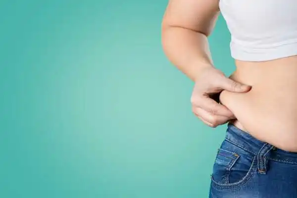 Image of woman pinching her love handles to show weight gain Llanelli