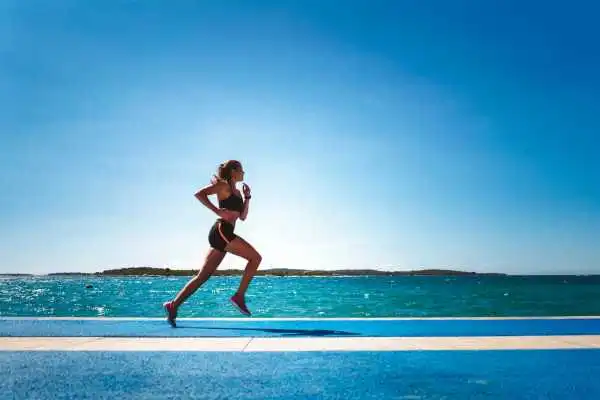 Woman running showing strong leg muscle Llanelli